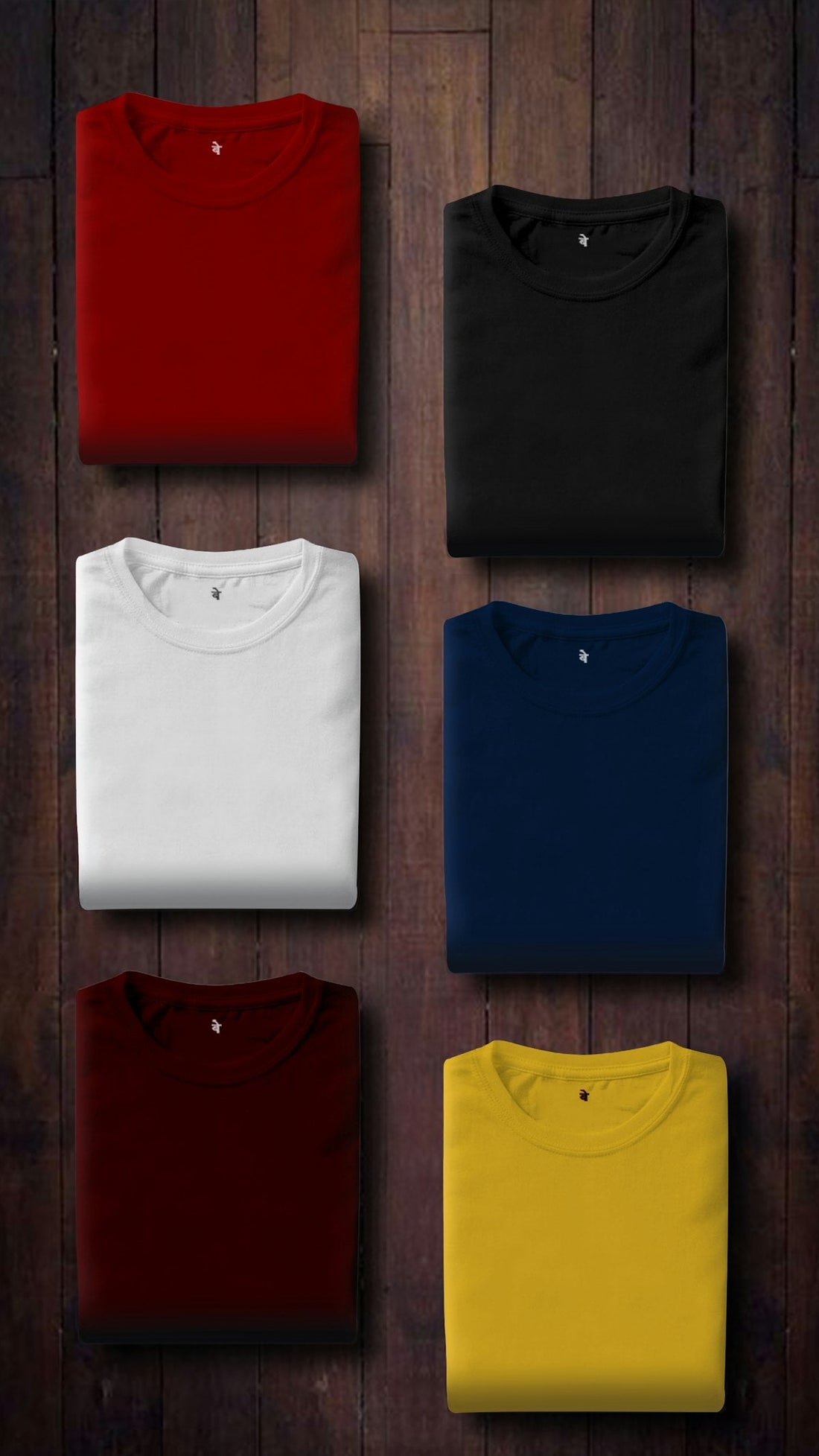 Assorted colourful folded t-shirts stacked on a wooden panel